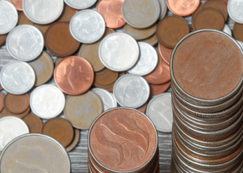 A birdseye view of coins stacked in increasing height, representing savings growth