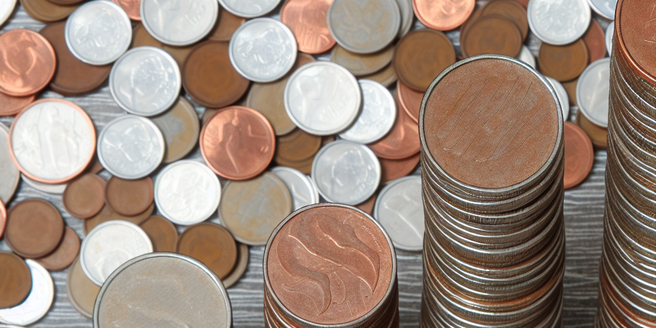 A birdseye view of coins stacked in increasing height, representing savings growth