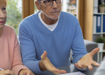 A financial advisor explaining to a retired couple about the impact of credit use on their credit score