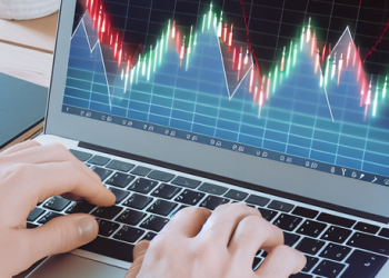 A person using a laptop to view stock market trends, showing active financial planning