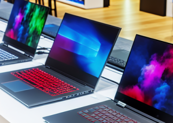 An array of top-tier laptops showcased side by side in a modern tech store